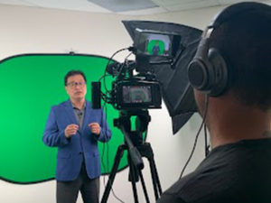 image of a person filming another person in front of a green screen